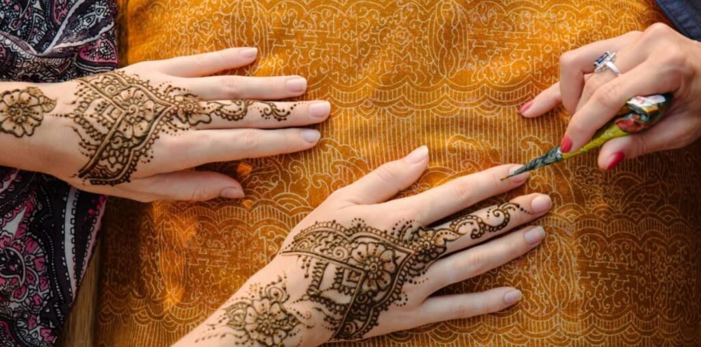 Applying mehndi with homemade cone
